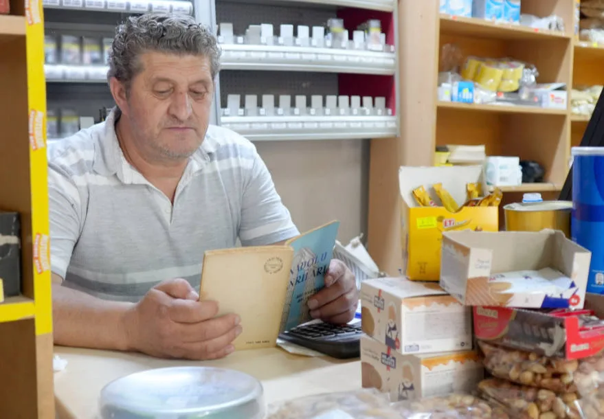 Tekirdağlı bakkal kitap okuma tutkusunu iş yerinde de sürdürüyor